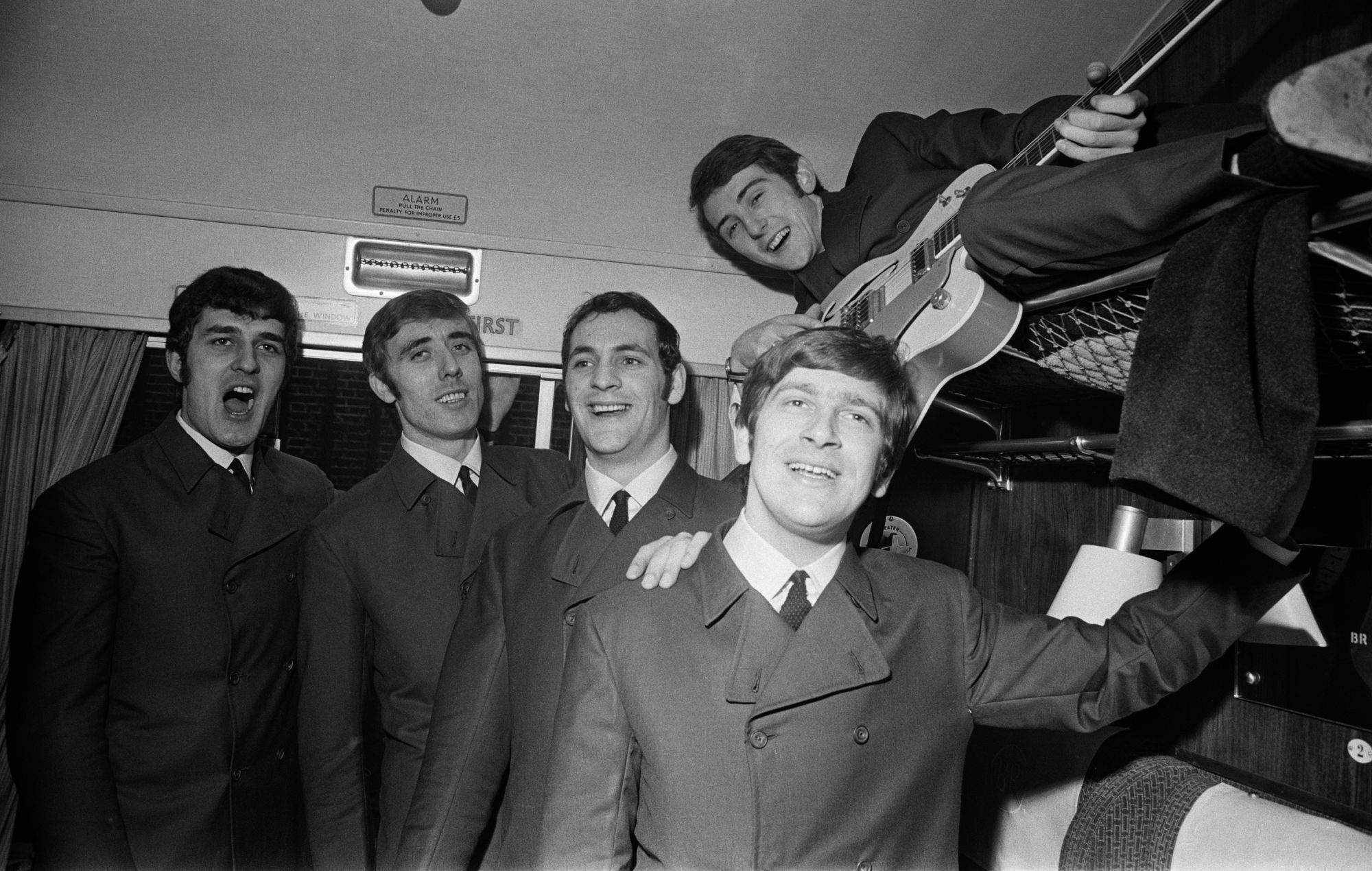 Le groupe de rock anglais The Moody Blues pose pour une photo dans un wagon de première classe à bord d'un train, le 11 novembre 1964. De gauche à droite : Ray Thomas, Clint Warwick, Mike Pinder, Graeme Edge et Denny Laine (sur une étagère).