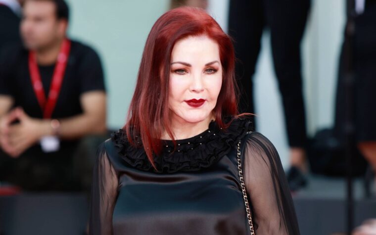 Priscilla Presley waves as she arrives for a press conference in Vienna, Austria on February 7, 2024, where she will be guest of honour at this year