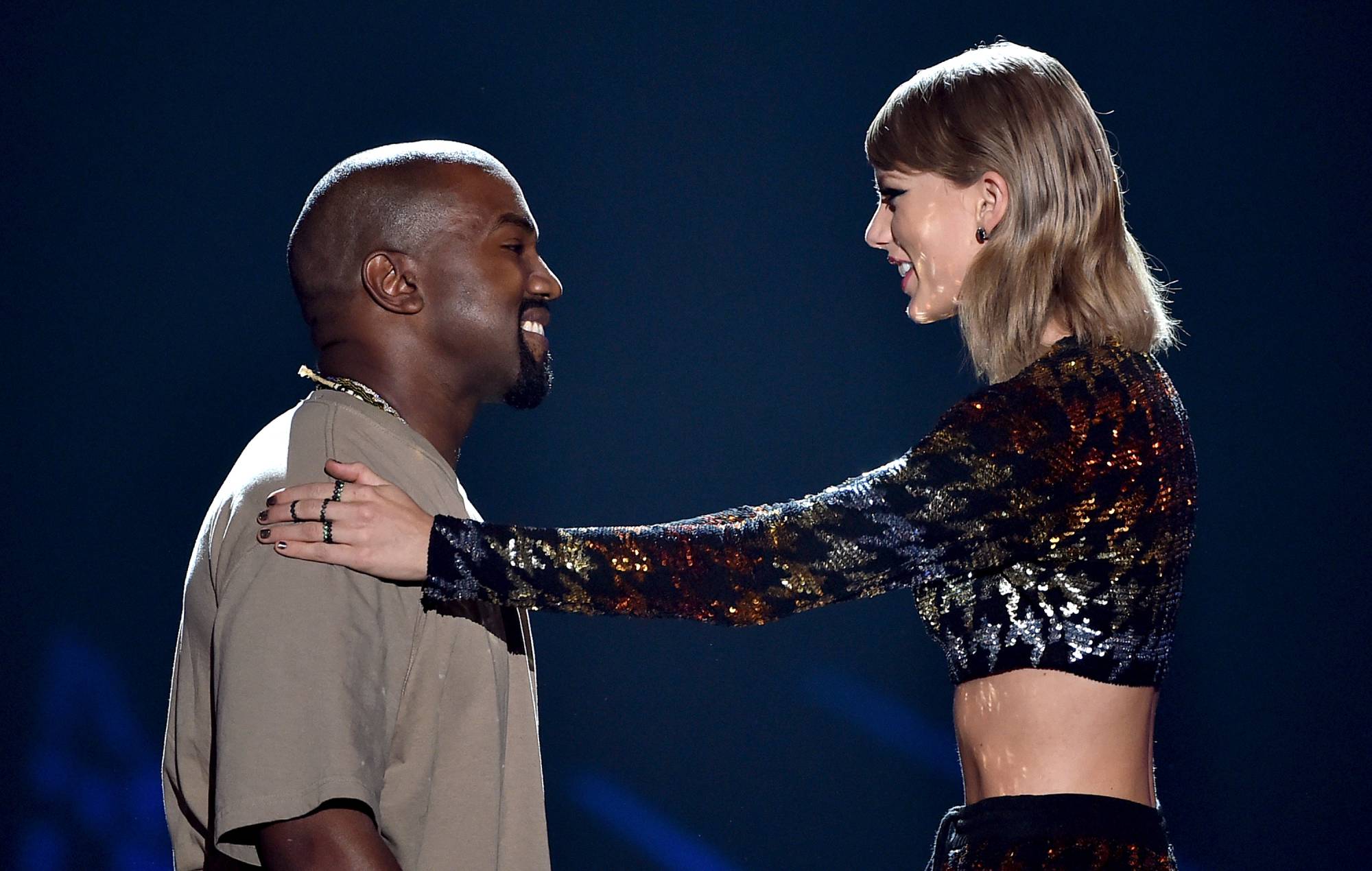   Kanye West (à gauche) reçoit le Video Vanguard Award des mains de l'artiste Taylor Swift sur scène lors des MTV Video Music Awards 2015 au Microsoft Theater le 30 août 2015 à Los Angeles, en Californie. (Photo de Kevin Winter/MTV1415/Getty Images pour MTV)