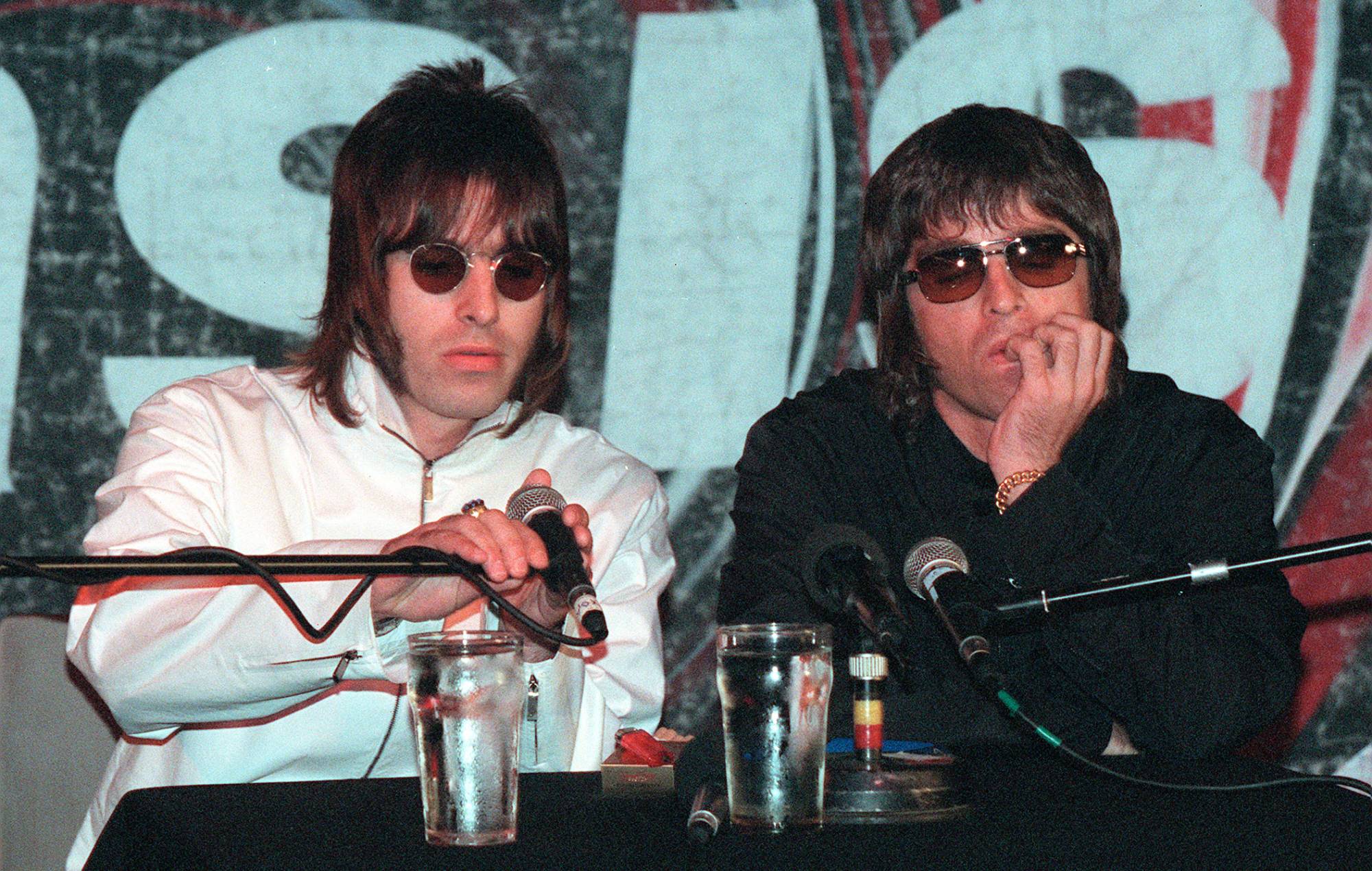 Liam et Noel Gallagher d'Oasis lors d'une conférence de presse tenue au pub Waterrats à Londres, le 25 août 1999. La conférence a été convoquée pour annoncer le départ des deux membres fondateurs du groupe, Guigsy et Bonehead, qui ont été remplacés par Gem Archer et Andy Bell. CRÉDIT : Gareth Davies/Getty Images