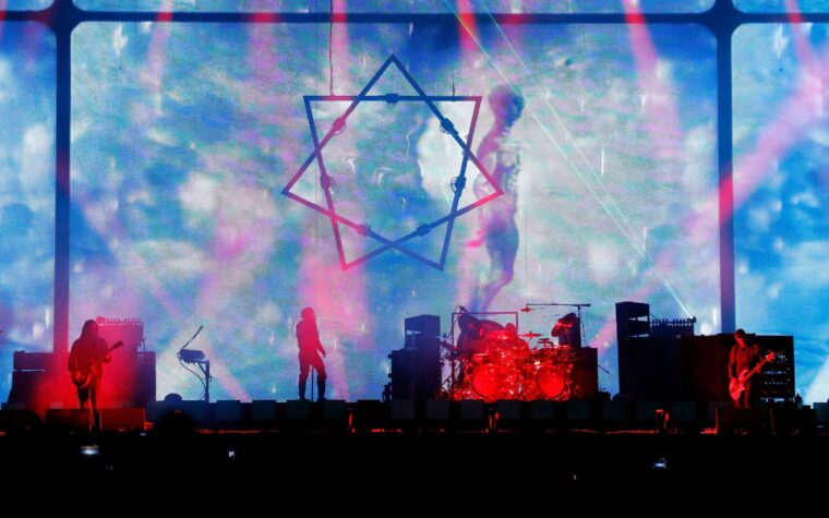 Regardez Justin Chancellor de Tool porter un déguisement de Willy Wonka pour faire une farce au groupe de soutien sur scène