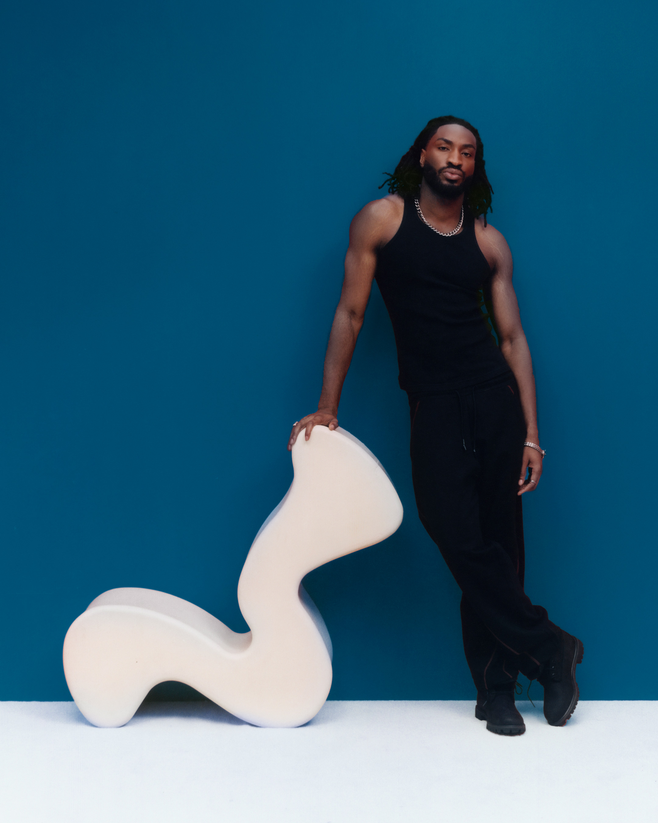Odeal debout contre une chaise blanche ondulée, photo d'Elliot Hensford