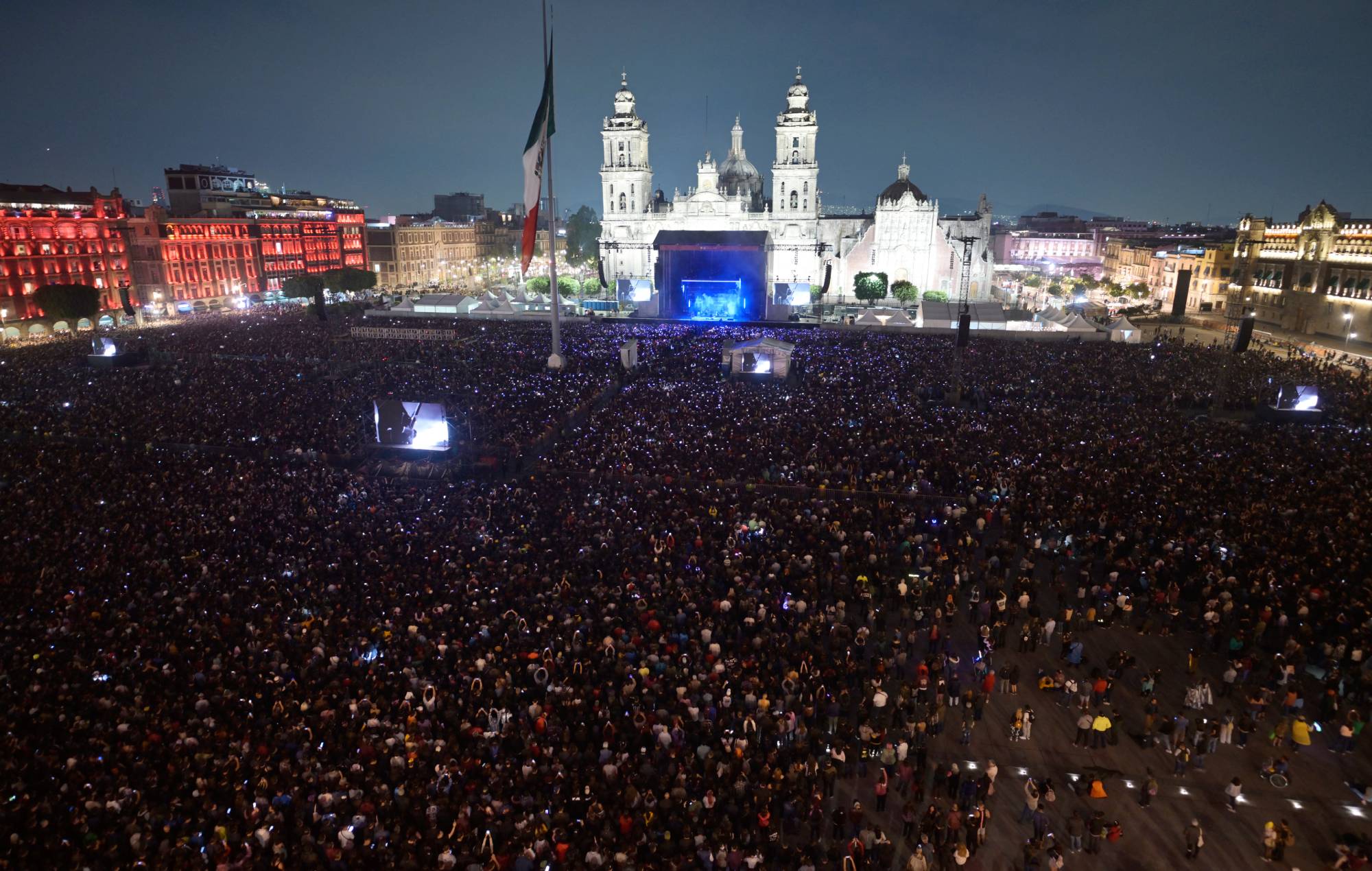 Les gens se rassemblent pour entendre le groupe de rock américain Interpol se produire sur la place Zocalo à Mexico le 20 avril 2024. (Photo d'ALFREDO ESTRELLA / AFP) (Photo d'ALFREDO ESTRELLA/AFP via Getty Images)