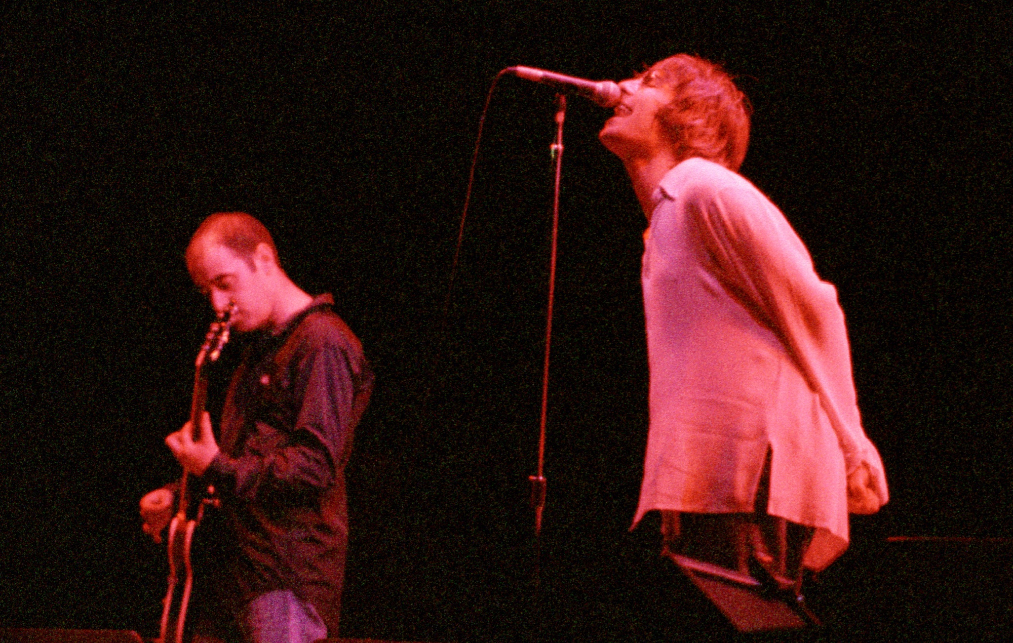 Paul 'Bonehead' Arthurs et Liam Gallagher sur scène avec Oasis en 1996
