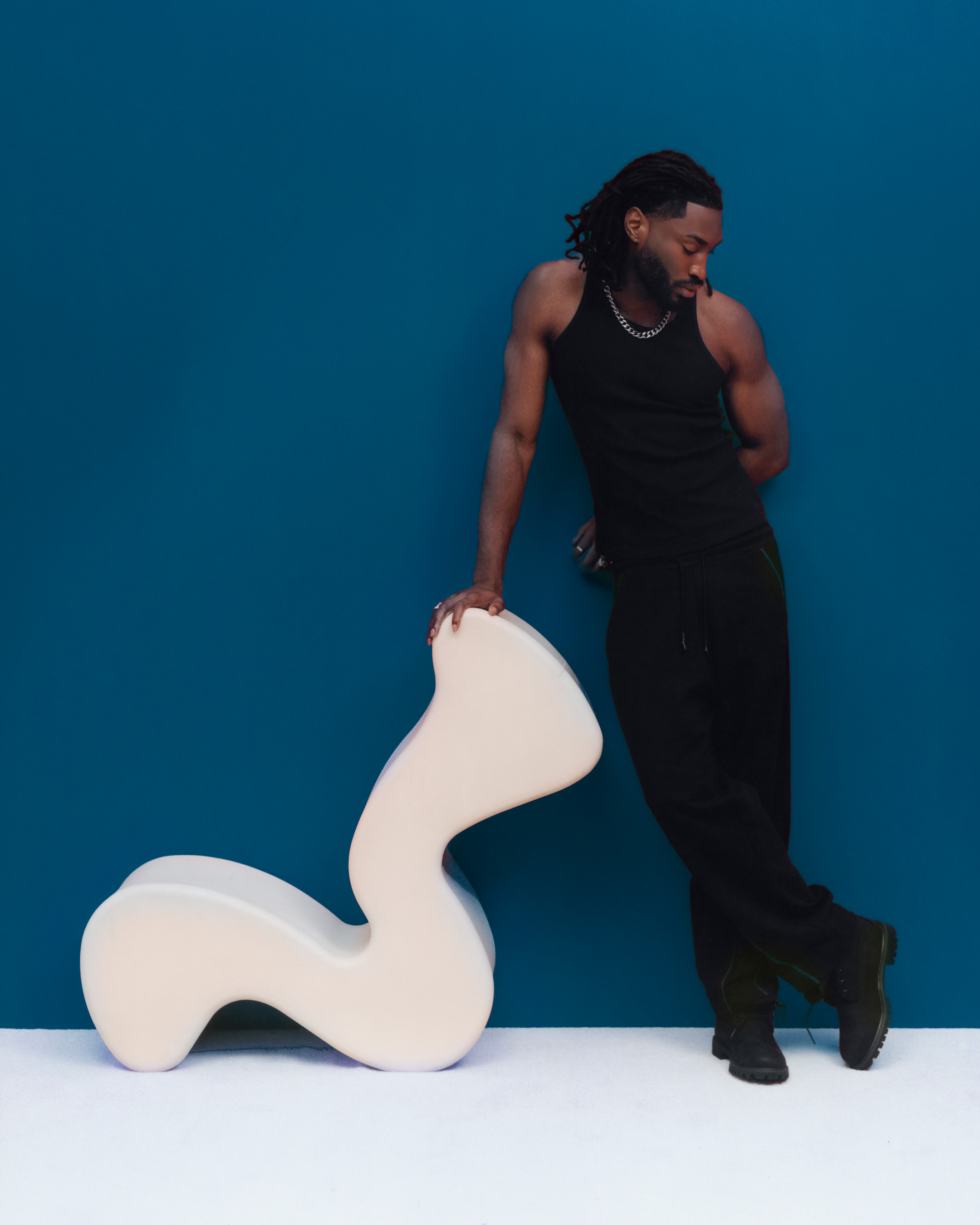Odeal debout contre une chaise blanche ondulée, photo d'Elliot Hensford