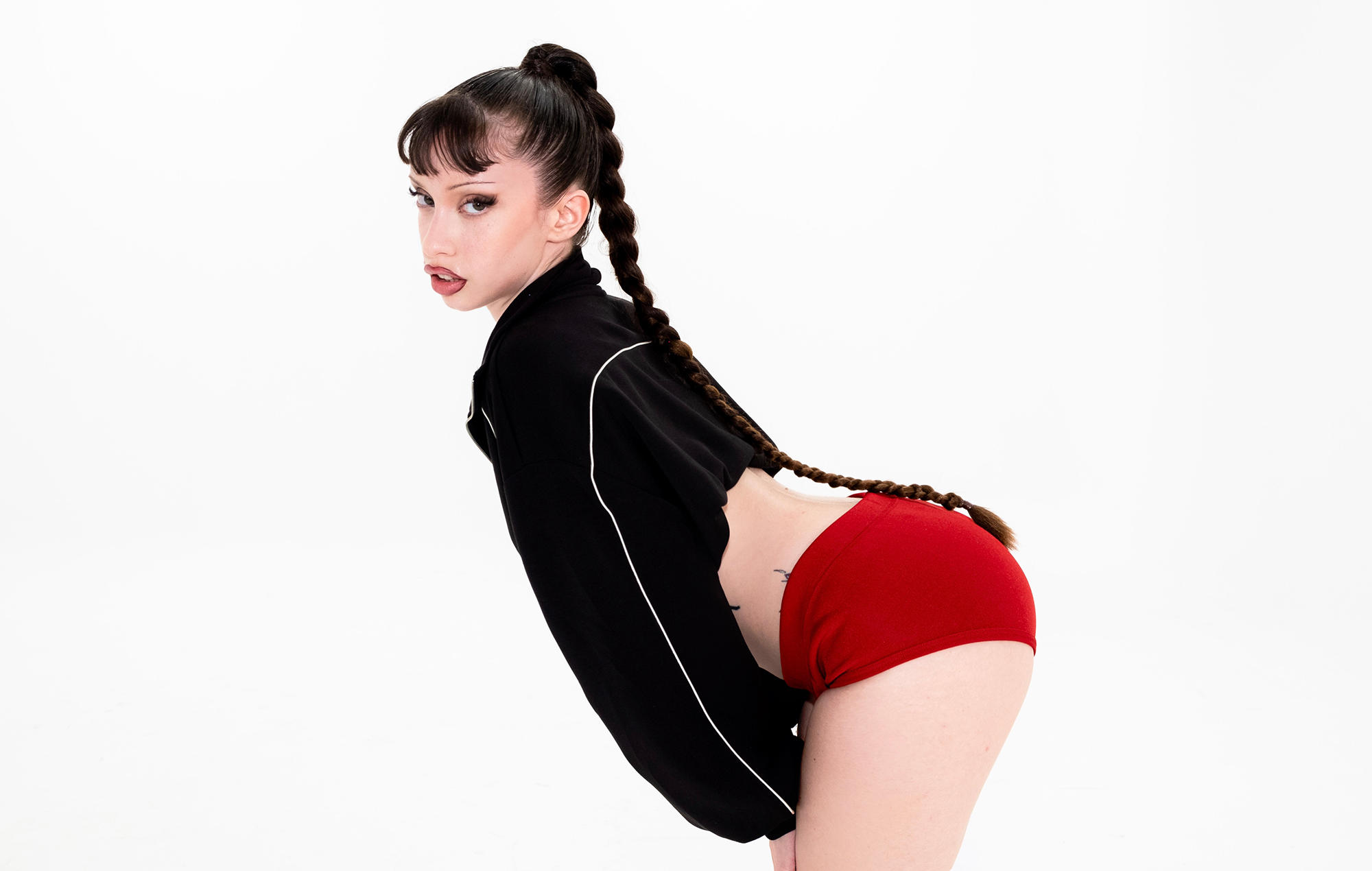 Six sexe photographié dans une veste noire et un short rouge, photo de Catalina Jacobo