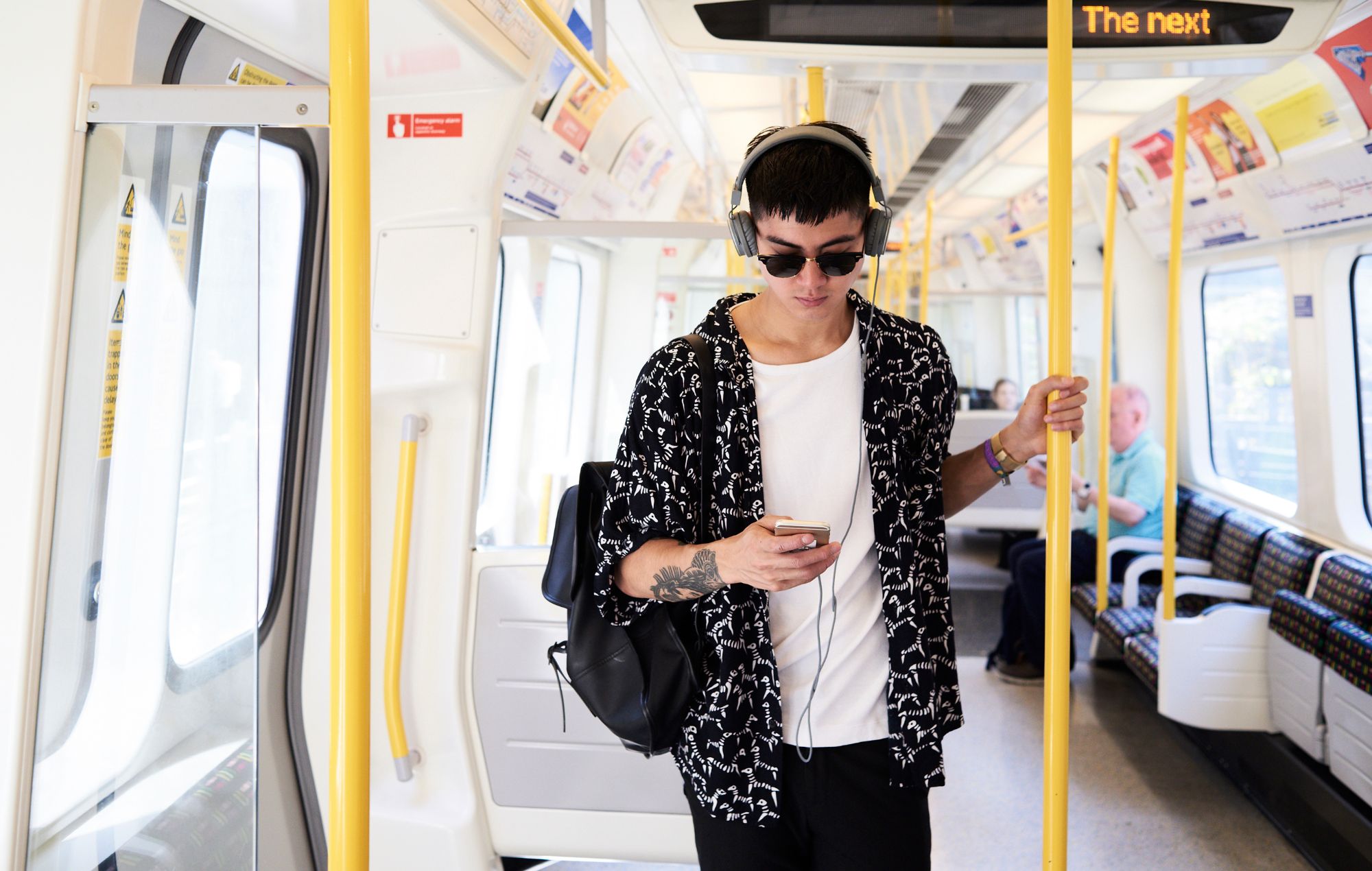 Jeune homme écoutant de la musique avec des écouteurs à l'intérieur du train, Royaume-Uni