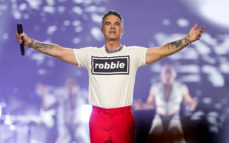 Regardez Robbie Williams surprendre ses fans en jouant dans la rue des « Anges » dans les rues de Séville Regardez Robbie Williams surprendre ses fans en jouant dans la rue des « Anges » dans les rues de Séville