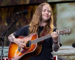 Billy Strings se produit avec un casque de protection après avoir été heurté par un objet sur scène