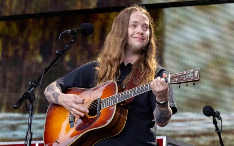Billy Strings se produit avec un casque de protection après avoir été heurté par un objet sur scène Billy Strings se produit avec un casque de protection après avoir été heurté par un objet sur scène